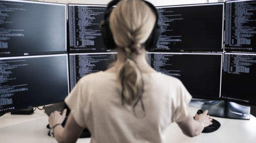 Sakerhetsbolagets-SRS-it-specialist-sitter-framfar-stor-datorskarm-och-arbetar-med-cybersakerhet